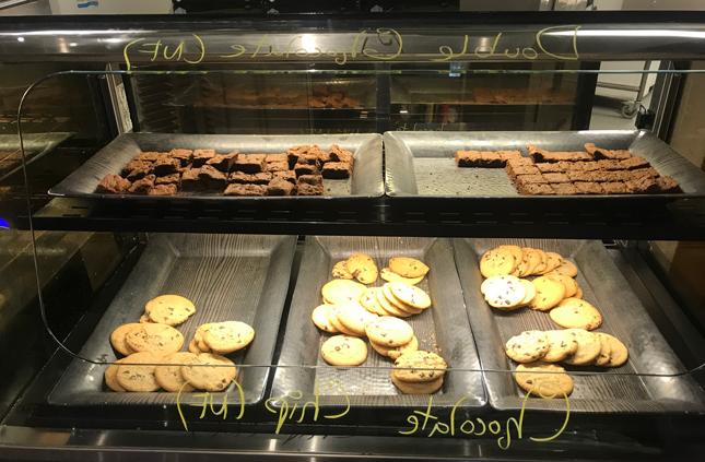 chocolate chip cookies and brownies in a display case